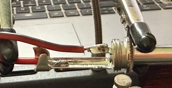 A close up of wires soldered to a 1/4" mono audio plug